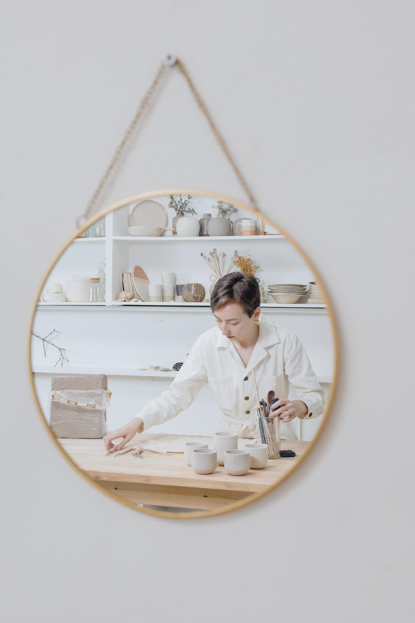 Student showcasing finished hoop on wall