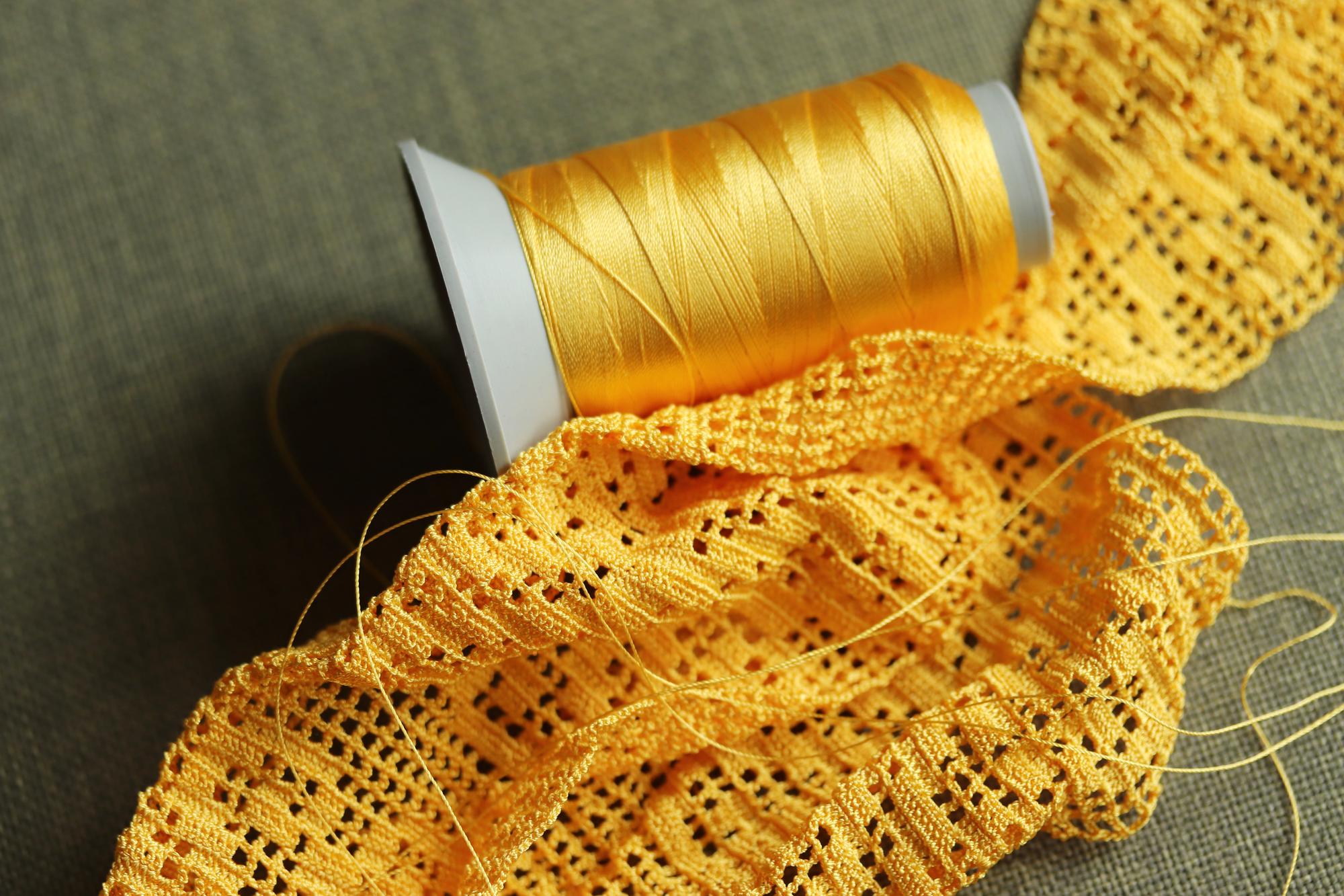Close-up of hand embroidery on linen with golden thread